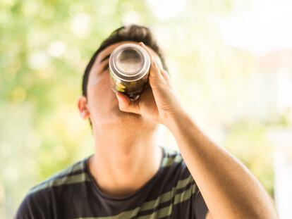 A young man drinking a can.