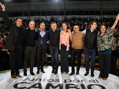 Mauricio Macri e a governadora de Buenos Aires, María Eugenia Vidal (centro), acenam para o público em Vicente López.