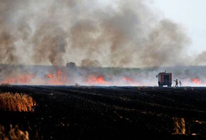 Soldados israelíes tratan de extinguir el fuego cerca de Kibbutz, a lo largo de la Franja de Gaza. 