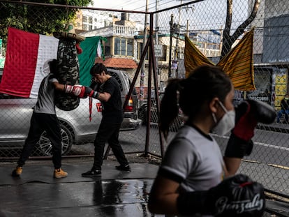 Una niña y dos jóvenes entrenan boxeo en una escuela ubicada en un bajopuente en Azcapotzalco, Ciudad de México, el 9 de septiembre de 2021.