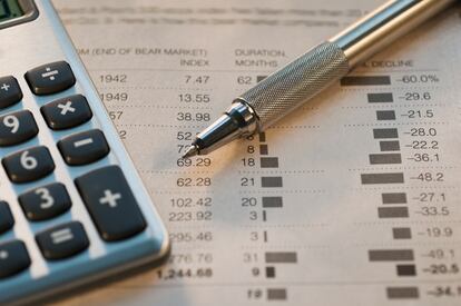 Close up of pen, calculator and financial pages