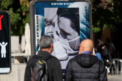 Dos viandantes observan uno de los carteles expuestos durante la presentación de la cuarta edición de "Madrid Gráfica", este lunes en Madrid.