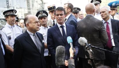 El primer ministro francés, Manuel Valls (centro), este domingo en París, en la estación de tren de Montparnasse.