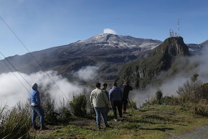Un grupo de personas observa el vapor y los gases que salen del volcán Nevado del Ruiz, el 19 de abril, desde el Cerro Gualí.