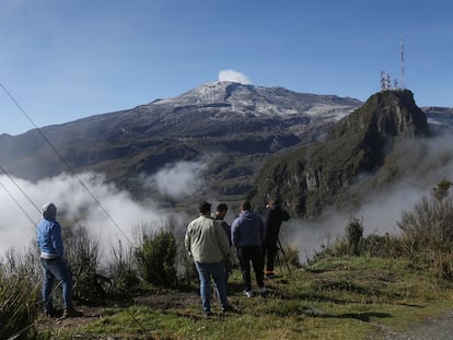 Un grupo de personas observa el vapor y los gases que salen del volcán Nevado del Ruiz, el 19 de abril, desde el Cerro Gualí.