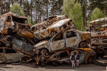 Unos niños observan los vehículos destruidos en Irpin, Ucrania, el pasado 8 de mayo.