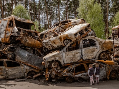 Unos niños observan los vehículos destruidos en Irpin, Ucrania, el pasado 8 de mayo.