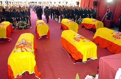 El funeral por los siete agentes fallecidos en Irak se celebró en la sede del Centro Nacional de Inteligencia, en Madrid, y reunió a familiares, a la izquierda, y autoridades, a la derecha.