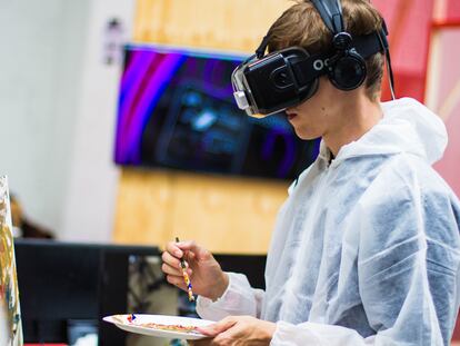 Un joven pinta con unas gafas de realidad virtual.