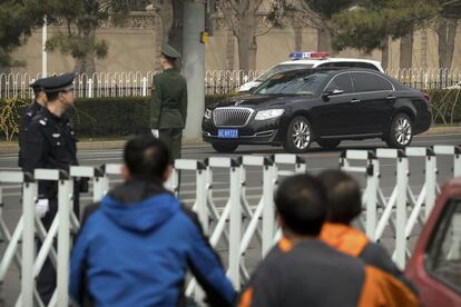 Policial e agentes de segurança montam guarda enquanto uma caravana de automóveis circula por uma estrada próxima à residência para hóspedes oficiais do Governo chinês. Ninguém confirma oficialmente, mas há fortes indícios de que o líder norte-coreano se reuniu com autoridades chinesas.