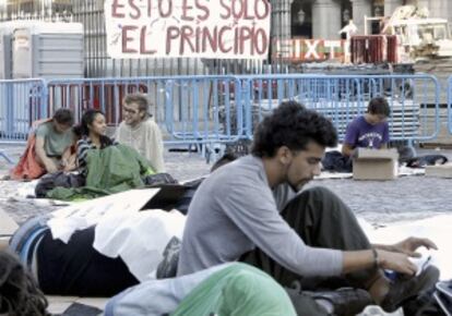 Varios indignados, esta mañana en la Plaza Mayor de Madrid, después de pasar la noche en el lugar y poco antes de ser desalojados.