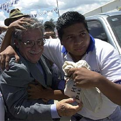 Ríos Montt (izquierda) es protegido por un guardaespaldas.