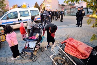 La polic&iacute;a francesa vigila a una familia gitana que desaloja un campamento en Roubaix el 3 de octubre.