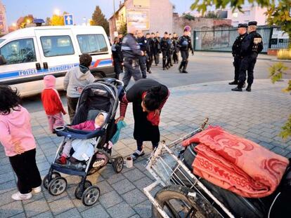 La polic&iacute;a francesa vigila a una familia gitana que desaloja un campamento en Roubaix el 3 de octubre.