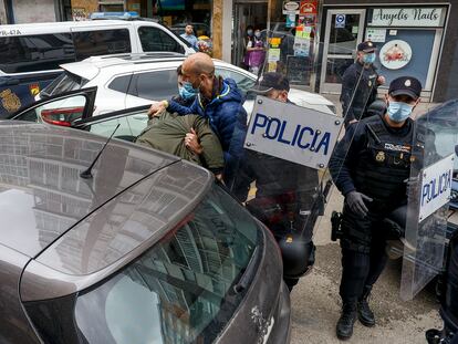 Agentes de Policía introducen en el coche a uno de los detenidos este sábado en una vivienda de la calle Francisco Grandmontagne de Burgos.