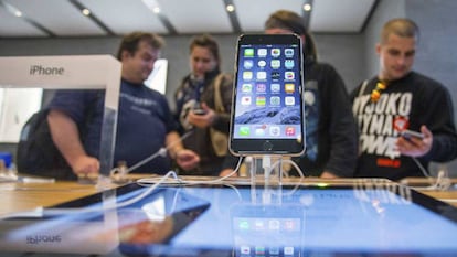Una iPhone 6, en una tienda en la que varias personas prueban móvilles.