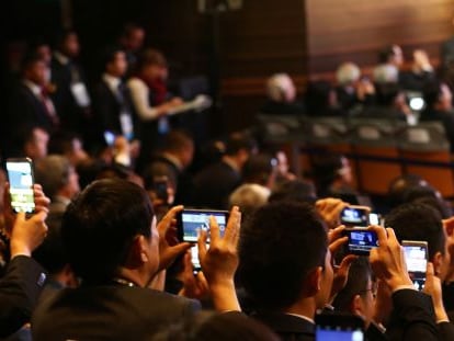 Asistentes a la cumbre de la APEC en Lima fotograf&iacute;an al presidente de China, Xi Jinping (fuera de imagen).