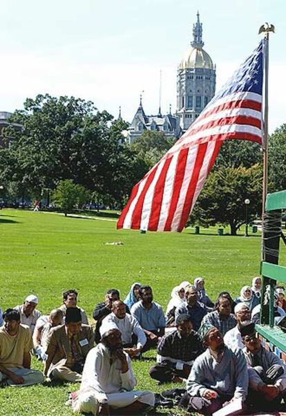 Un grupo de fieles sigue una ceremonia islámica en un parque de Connecticut.