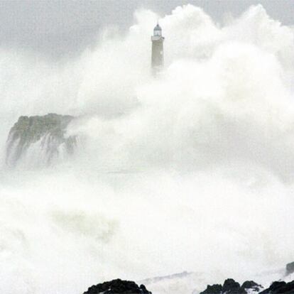 La ola rompe contra el faro de Mouro, en Santander