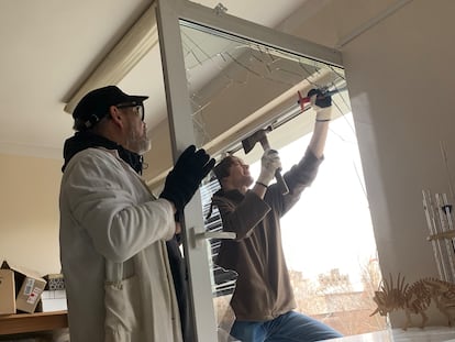 Dos personas reparan los destrozos en el laboratorio de Natalia Gerasimenko.