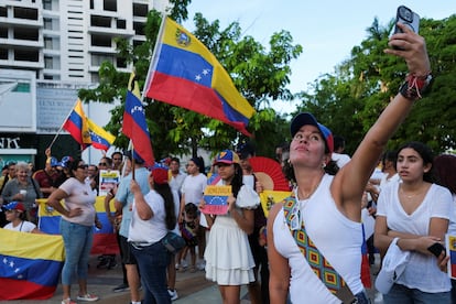 Una mujer se toma una foto durante una protesta global de partidarios de la oposición venezolana en Cancún (México).