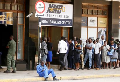 Varias personas hacen cola para retirar su dinero de un bancoo en Harare, la capital de Zimbabue.