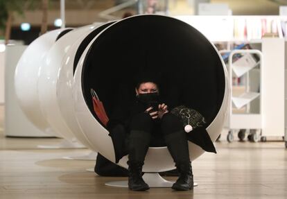 Una mujer descansa con su teléfono móvil en uno de los sillones huevo de la última planta.