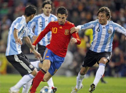 Cesc conduce el balón entre Di María, Gago y Heinze.