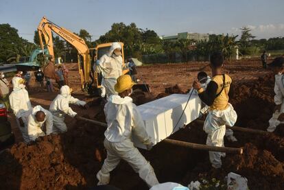 Sepultureros con equipos de protección personal llevan un ataúd para el entierro en un cementerio en Bekasi, mientras Indonesia enfrenta su brote más grave impulsado por la variante Delta altamente infecciosa de Covid-19.
