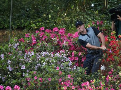 Rory McIlroy golpea la bola entre las azaleas, en el hoyo 13.