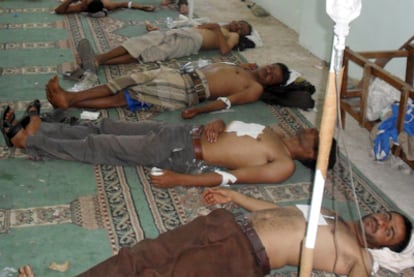 Manifestantes yemeníes heridos tras los enfrentamientos con la policía descansan en el suelo.