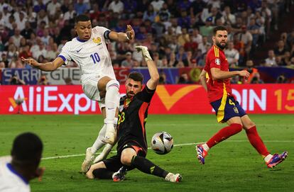 El guardameta español Unai Simón corta una acción de Kylian Mbappé.