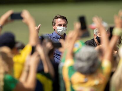 El presidente brasileño Jair Bolsonaro saluda a simpatizantes que le celebran su cumpleaños 66, este domingo en Brasilia.