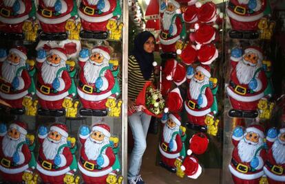 Una mujer palestina sale de una tienda decorada con adornos navideños, en Gaza.