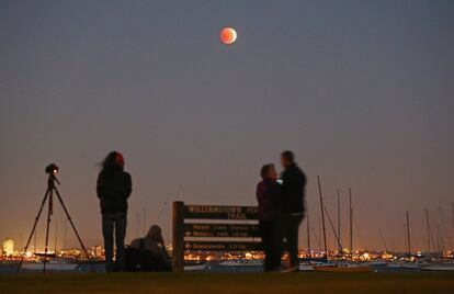 Personas disfrutan del eclipse lunar total en Melbourne, Australia. 