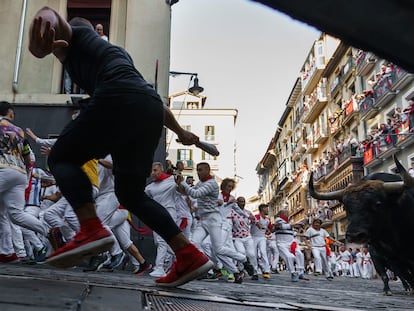 Los participantes corren delante de los toros durante el "encierro" de las fiestas de San Fermín en Pamplona, ​​norte de España.