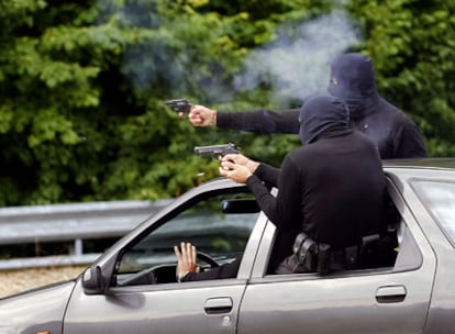Dos escoltas disparan un revólver y una pistola desde un coche a toda velocidad, simulando la respuesta a  un intento de atentado.
