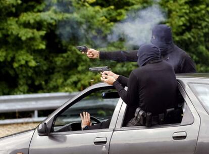 Dos escoltas disparan un revólver y una pistola desde un coche a toda velocidad, simulando la respuesta a  un intento de atentado.