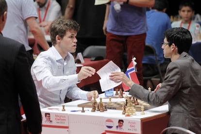 Carlsen acaba de convertirse en el ganador del torneo tras derrotar a Giri, y ambos se intercambian las planillas para firmarlas