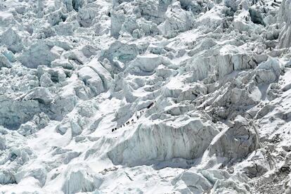 Escaladores atraviesan la cascada de hielo de Khumbu en el Monte Everest.