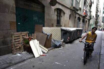 Colchones, cajas, sillas y diversos objetos en la calle de Carretes, en el barrio del Raval. 

/