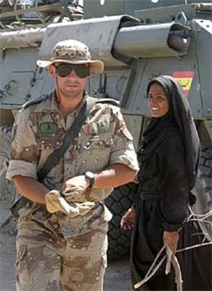 Un soldado español camina junto a una mujer en Diwaniya.