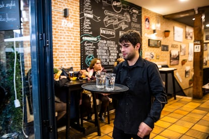 Un camarero con dos vasos de agua en un bar en las inmediaciones de la Plaza Mayor, en Madrid. 