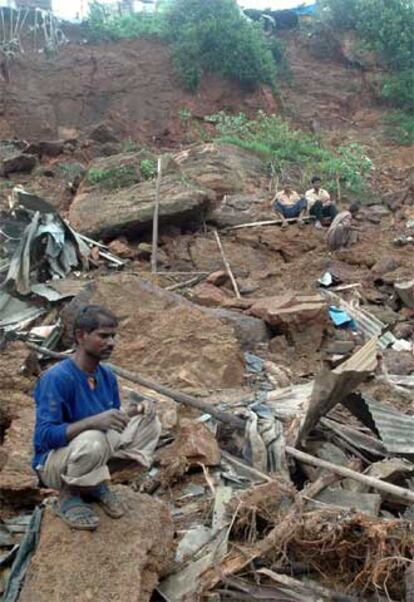 Varios vecinos contemplan la destrucción de su barrio, en Bombay.