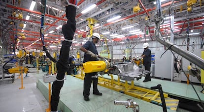 Dos trabajadores en una línea de montaje.
