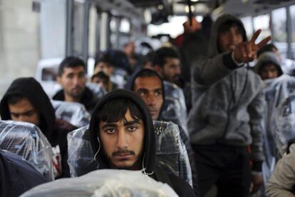 Migrantes sentados en un autobús, camino de salir del campo de migrantes de Calais (Francia). 