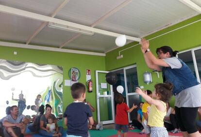 Varios niños cantan y bailan durante la actividad con Lorena García (a la derecha).