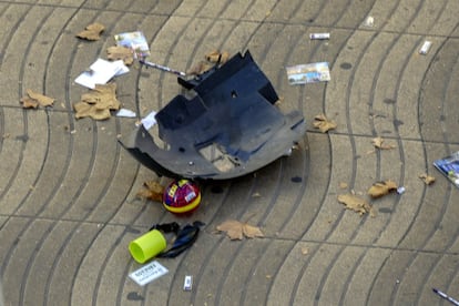 Restos del parachoques frontal de la furgoneta después de impactar con los expositores de postales del quiosco de la Rambla.