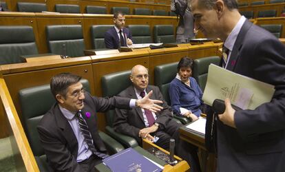 El <i>lehendakari,</i> Patxi López (izquierda), que lleva en la solapa una chapa morada contra la violencia de género, junto al consejero vasco de Interior, Rodolfo Ares (segundo por la izquierda), conversa con el portavoz del PP, Leopoldo Barreda (derecha), momentos antes del pleno del Parlamento vasco en el que se ha leído una declaración institucional con motivo del día contra la violencia hacia las mujeres.