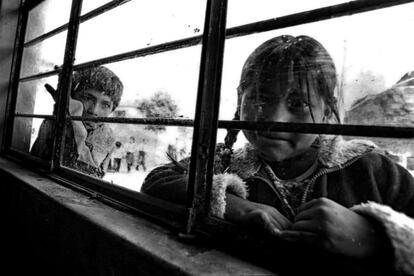 Una niña y un niño se asoman desde el exterior a una de las aulas de apoyo escolar de ADEVI. Esta ONG no puede ayudar a todos los niños y niñas de Huachipa, pero al menos un centenar de ellos pasan cada año por sus aulas.